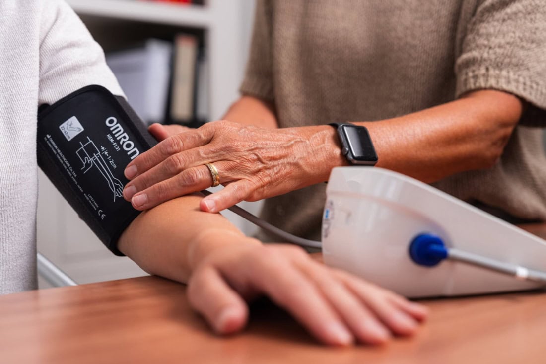 Bloeddruk meten thuis met digitale bloeddrukmeter en armmanchet, ouderen gezondheidszorg.