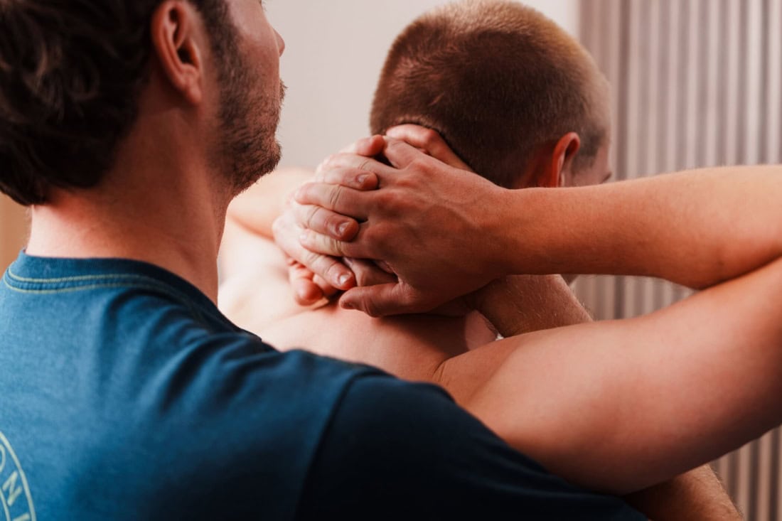 Man krijgt nek- en schoudermassage voor bewegingsklachten.